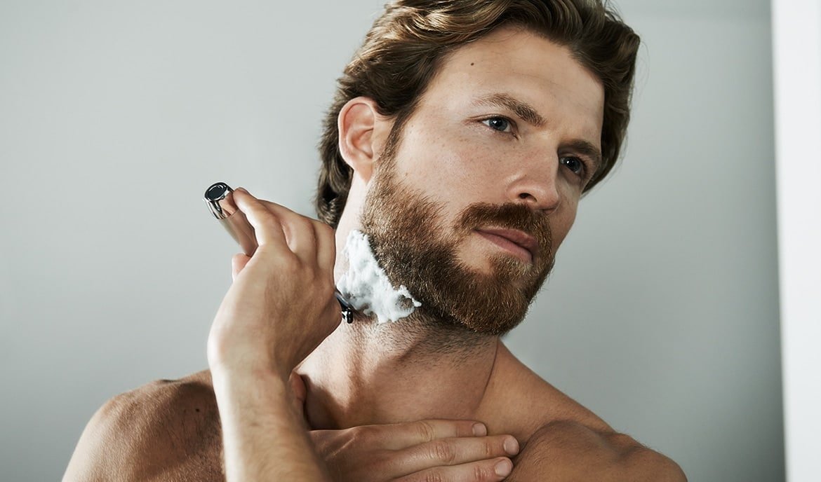 Mann rasiert sich nass im Gesicht